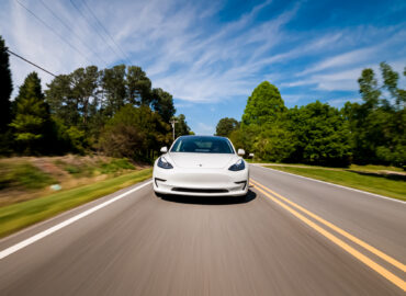 RALEIGH, NC USA, APRIL 17, 2020: A new Tesla Model 3 all electric vehicle driving down a country road